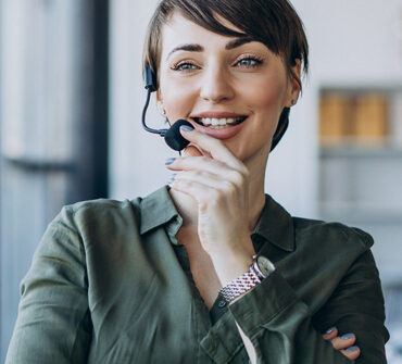 Woman wearing a headset, smiling, and engaging with audio content, representing a host for Blueprints and Beginnings.